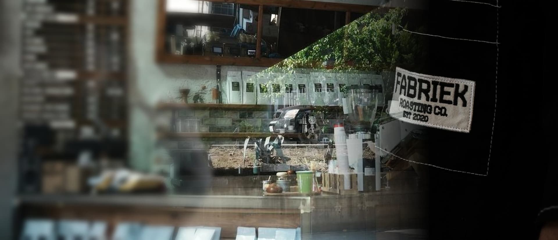 Kahve poşetli tezgâh ve siyah FABRIEK Roasting Co. iş ceketi